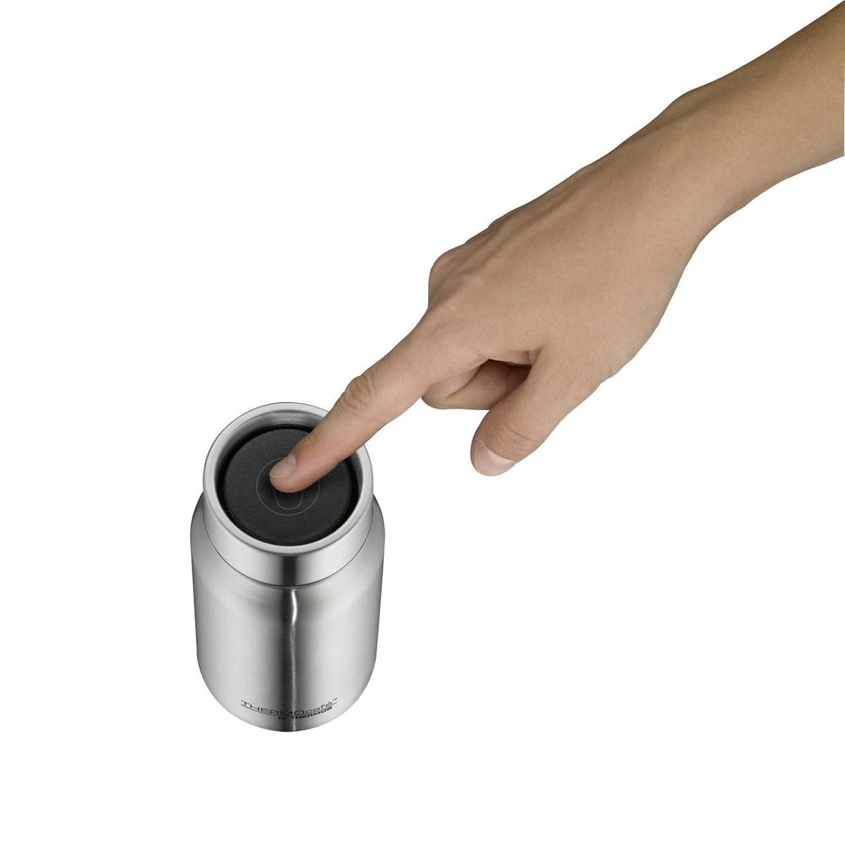 Eine Hand drückt mit dem Zeigefinger auf den Deckel eines silbernen, zylinderförmigen Behälters. Der Behälter hat ein minimalistisches Design und der Deckel scheint aus einem dunkleren Material zu bestehen.