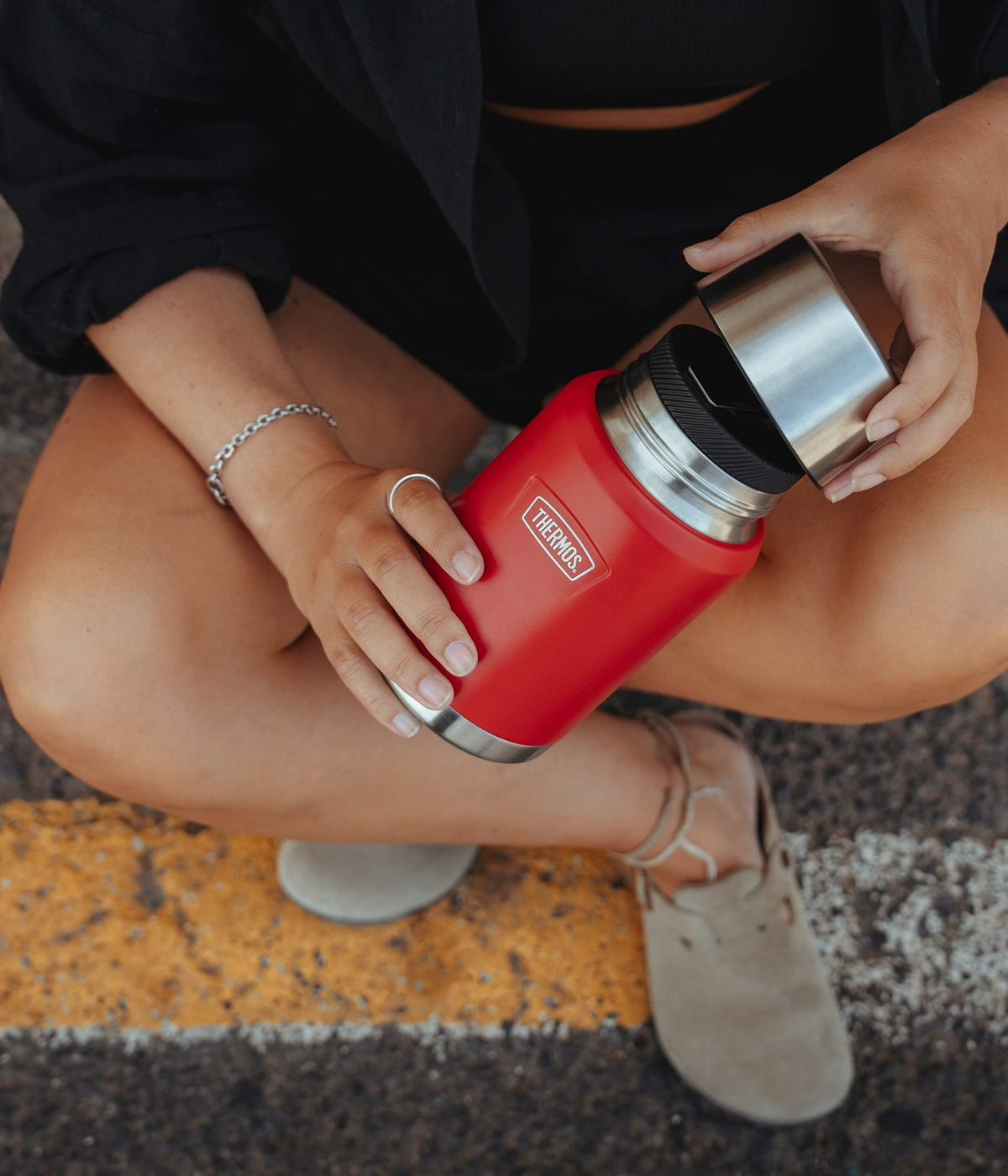 Roter Thermobehälter in der Hand bei einer Outdoor-Szene